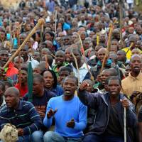 Striking out: Miners march during a strike over pay increases near the Marikana platinum mine in Marikana, South Africa, in September 2012. Police, mine officials met before Marikana killings