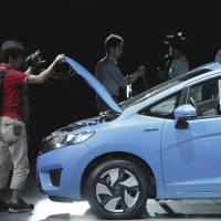 Fleeting milestone?: Reporters look at Honda Motor Co.\'s new Fit Hybrid displayed at its launch in Urayasu, Chiba Prefecture, on Sept. 5. | BLOOMBERG