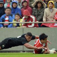 Rout: New Zealand\'s Charles Piutau tackles Japan\'s Yu Tamura in Saturday\'s test match at Chichibunomiya Stadium. The All Blacks won 54-6. | AFP-JIJI