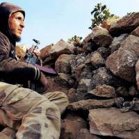 Battled hardened: A Free Syrian Army fighter rests during a battle against the government troops loyal to President Bashar Assad in Aleppo, Syria, on Wednesday. | AP