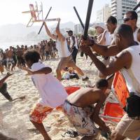 Seaside robbery: Municipal guards chase a gang of thieves that stole bags and wallets from people on Rio de Janeiro\'s Arpoador beach Wednesday. | AP