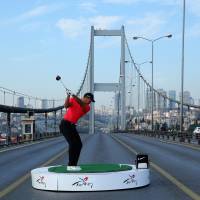 Tiger Woods tees off Tuesday on Istanbul\'s 1,560-meter Bosphorous Bridge linking Asia and Europe, making history by hitting the first golf shots from West to East. | KYODO