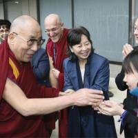 Supporters of the exiled Tibetan spiritual leader the Dalai Lama welcome him following his arrival Friday at Narita International Airport. During his stay in Japan through Nov. 26, the Dalai Lama is scheduled to attend talk events and give lectures in Tokyo and other cities. | KYODO
