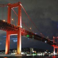 Wakato Ohashi Bridge in Kitakyushu is lit up with red LEDs on Thursday night to celebrate the 50th anniversary of the city\'s founding. The special illumination will last until the end of next March. | KYODO
