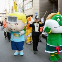 Drug company mascots parade Friday during the Shinno-sai festival put on by Sukunahikona Shrine, which is dedicated to the gods of both Japanese and Chinese medicine, in the Doshomachi district of the city of Osaka. The area hosts many pharmaceutical wholesalers. | KYODO