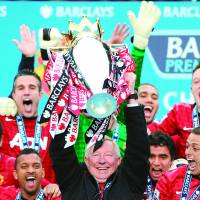 Out in a blaze of glory: Retiring Manchester United manager Alex Ferguson lifts the trophy as he and his team celebrate the 13th Premier League title of his 26-year tenure at Old Trafford. | AFP-JIJI