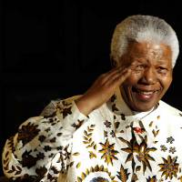Former South African President Nelson Mandela salutes the South African military health service band that performed for him on his 85th birthday. Mandela died Dec. 5 at the age of 95. | SATOKO KAWASAKI