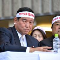 Wooing the skeptics: At a public meeting on Dec. 3 in  Tokyo about the Trans-Pacific Partnership talks, Liberal Democratic Party Secretary-General Shigeru Ishiba (left) wears a headband with a slogan calling for a parliamentary vote on any deal reached in the negotiations. The government\'s new state secrets bill could have a chilling effect on journalists reporting on the talks. | AFP-JIJI