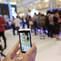 Self-obsession: A sales person takes a “selfie” to demonstrate a mobile-phone camera, now an all-important tool of social media. Gary Vaynerchuk, CEO of VaynerMedia and social-media expert, claims that Instagram, Twitter, Facebook and the like have spawned a culture of self-aggrandizement through online bragging. Can social media boast an antidote for bragging?