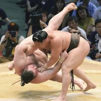 King of the castle: Hakuho throws Gagamaru to the ground at the Nagoya Grand Sumo Tournament in July.   | KYODO