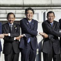 The thin grey line: Prime Minister Shinzo Abe poses in Tokyo on Saturday with (from left) Vietnamese Prime Minister Nguyen Tan Dung, Sultan Hassanal Bolkiah of Brunei, Cambodian Prime Minister Hun Sen and Indonesian President Susilo Bambang Yudhoyono. | POOL