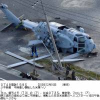 Black Hawk down: A U.S. Navy helicopter lays on its side at a landfill near Misaki Port in Miura, Kanagawa Prefecture, after making an emergency landing that injured two of its four crew members. | KYODO