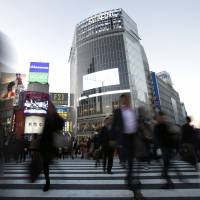 Cooperative convergence: Pedestrians cross the main intersection in front of JR Shibuya Station in Tokyo on Nov. 22. | BLOOMBERG