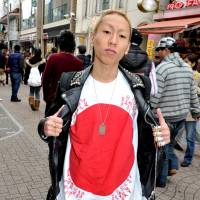 Showing the flag: Daisuke Sumii, 24, a salesman at a Harajuku clothes shop, shows off a T-shirt with the slogan \"This is Japanese rock\" while walking through Takeshita-dori. | YOSHIAKI MIURA