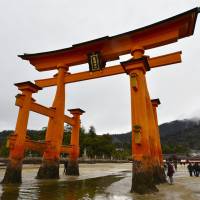 Troublesome tradition: The gate of Itsukushima Shrine in Hatsukaichi, Hiroshima Prefecture, stands offshore but can be approached on foot during low tide. | KYODO