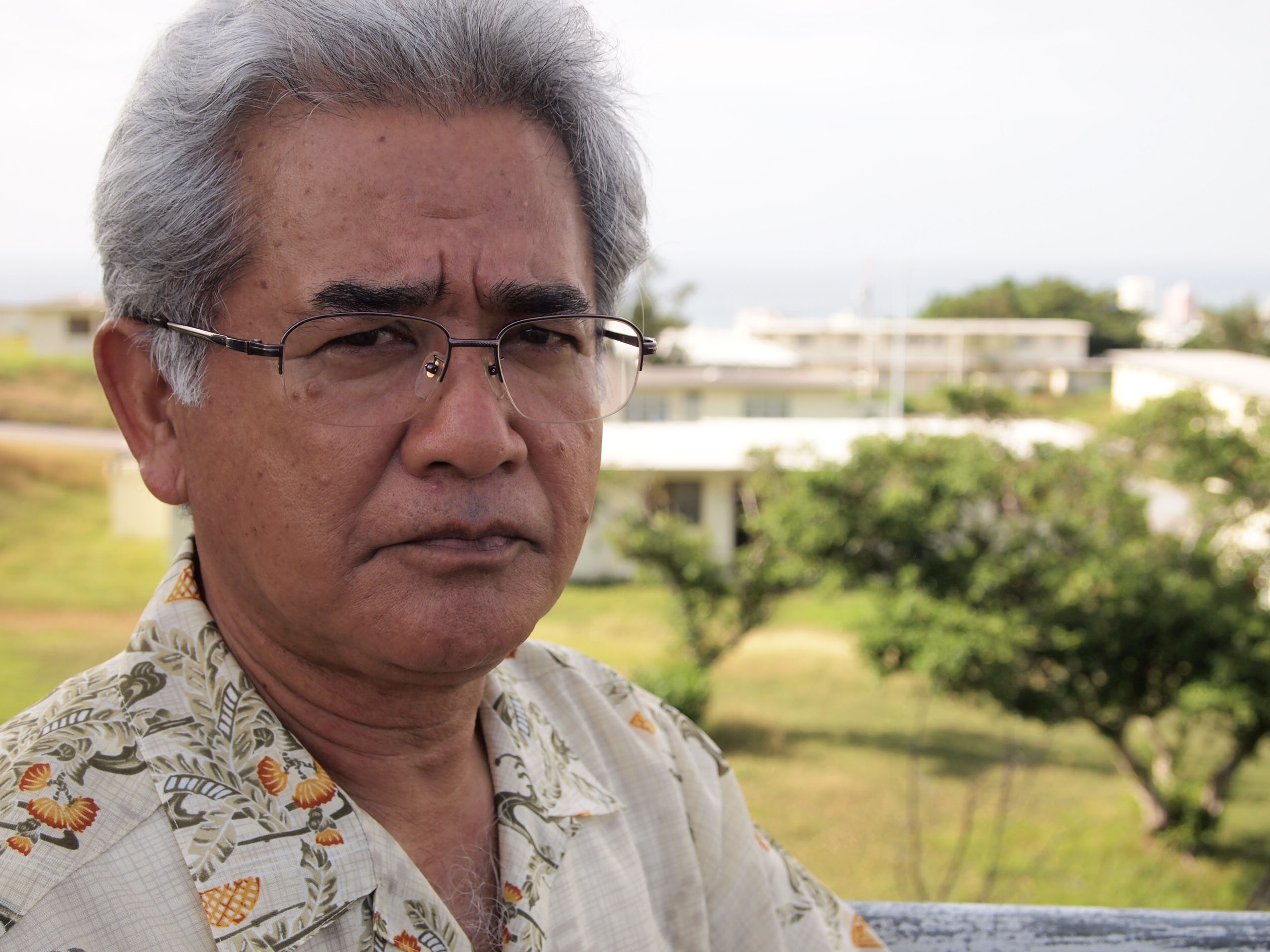 Tainted legacy: Seiryo Arakaki (above), chairman of the Okinawa Prefectural Assembly's special committee on U.S. bases, stands at the former U.S. military land of Nishi-Futenma, while pollution fears leave the housing area's redevelopment in limbo. | JON MITCHELL