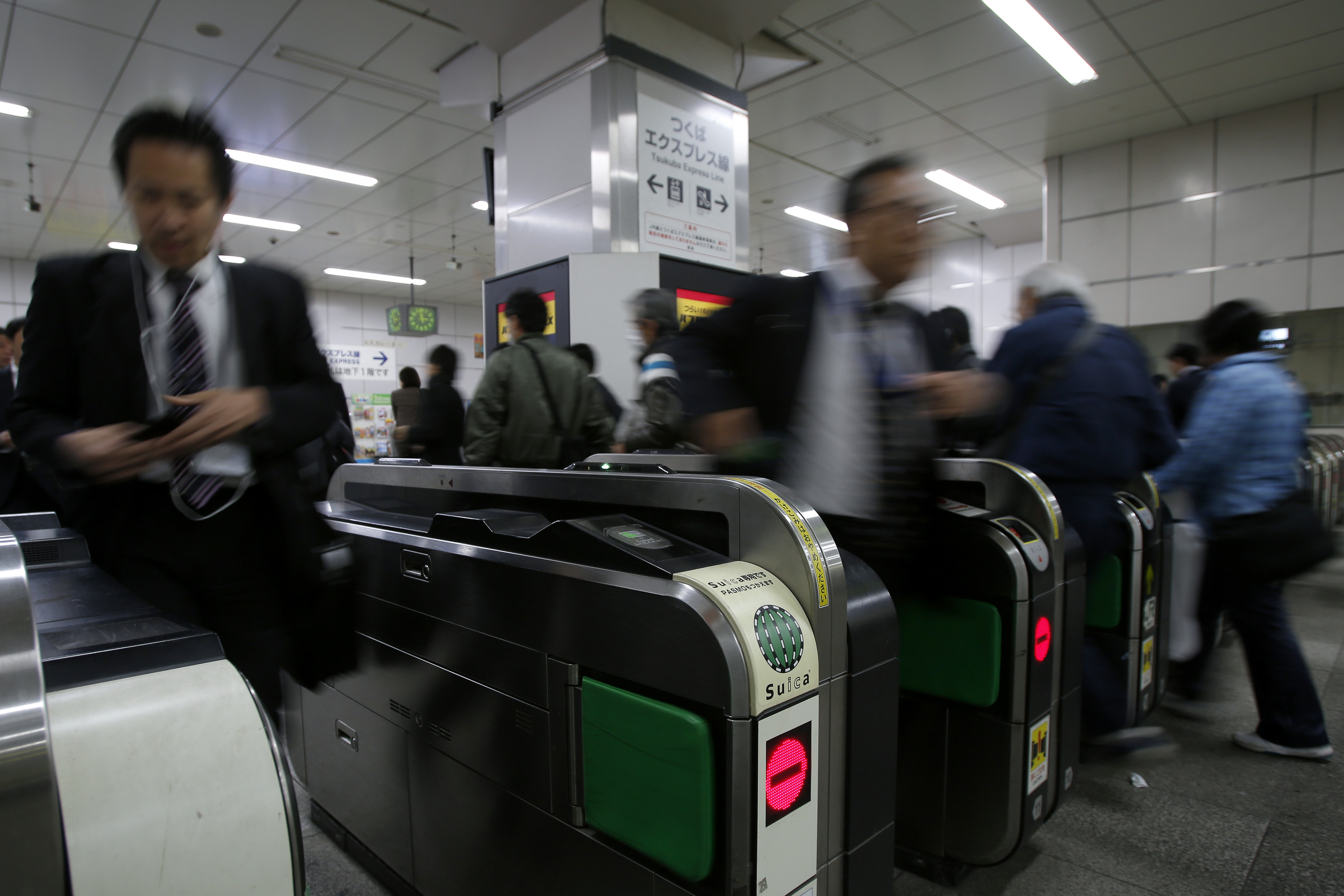 Pay as you go: People pass through ticket gates at a Tokyo train station on Nov. 13. | BLOOMBERG