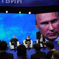 The overseer: Russian President Vladimir Putin (seated, at left) answers questions at a meeting of the All-Russia People\'s Front at the Academy of State Service in Moscow on Thursday. | AFP-JIJI