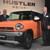 Bumper crop: Suzuki Motor Corp. President Osamu Suzuki (right) shows off the company\'s new Hustler mini sport utility vehicle at a news conference Tuesday in Tokyo. | AFP-JIJI