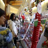 Yule pick one: People look at a Christmas card display at a Tokyo shopping mall Thursday. | BLOOMBERG