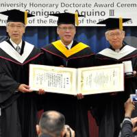 Philippine President Benigno S. Aquino III (center) holds his honorary doctorate diploma with Sophia University President Tadashi Takizawa (left) and Sophia School Corp. Chancellor Toshiaki Koso after receiving it at a ceremony at the university\'s Yotsuya Campus in Tokyo on Friday. | YOSHIAKI MIURA