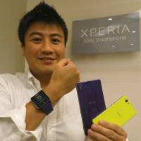 A piece of the pie: Kichiro Kurozumi shows off Sony Mobile Communications Inc.\'s Xperia handsets and smartwatch at the firm\'s headquarters in October. | KAZUAKI NAGATA
