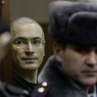Waiting for freedom: Mikhail Khodorkovsky (left) looks from behind glass at a courtroom in Moscow on Dec. 30, 2010. | AP
