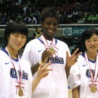 The champions: Oka Gakuen players (from left) Ai Yamada, Evelyn Mawuli and Sara Sakai proudly display their first-place medals after a 79-69 triumph over Gifu Girls in the All-Japan High School Tournament final on Saturday at Tokyo Metropolitan Gymnasium. Oka Gakuen captures back-to-back Winter Cup titles