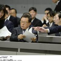 Facing the music: Tokyo Gov. Naoki Inose (center) looks at his papers as he prepares to respond to a committee from the Tokyo Metropolitan Assembly on Monday. | KYODO