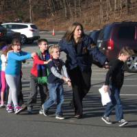 March to safety: Connecticut state police lead a line of children from Sandy Hook Elementary School in Newtown, Connecticut on Dec. 14, 2012, after a mass shooting at the school. | AP