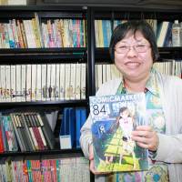 Well organized: Comic Market Committee co-representative Kahoru Yasuda holds a copy of the phonebook-sized catalog for Comiket 84. | JUN HONGO