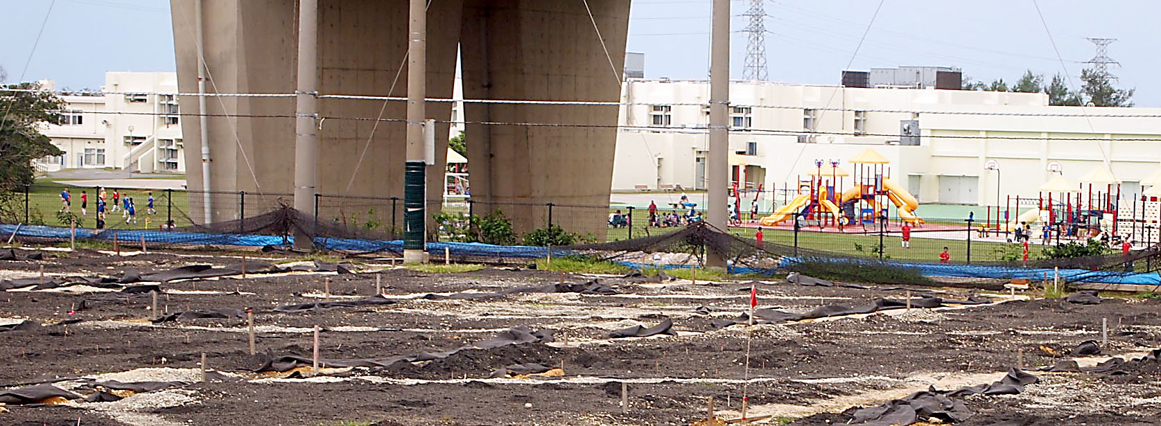 Dangerous game: Children play outside their school at the Kadena Air Base in November near dioxin-contaminated land (foreground) that is off-limits to the public. | JON MITCHELL