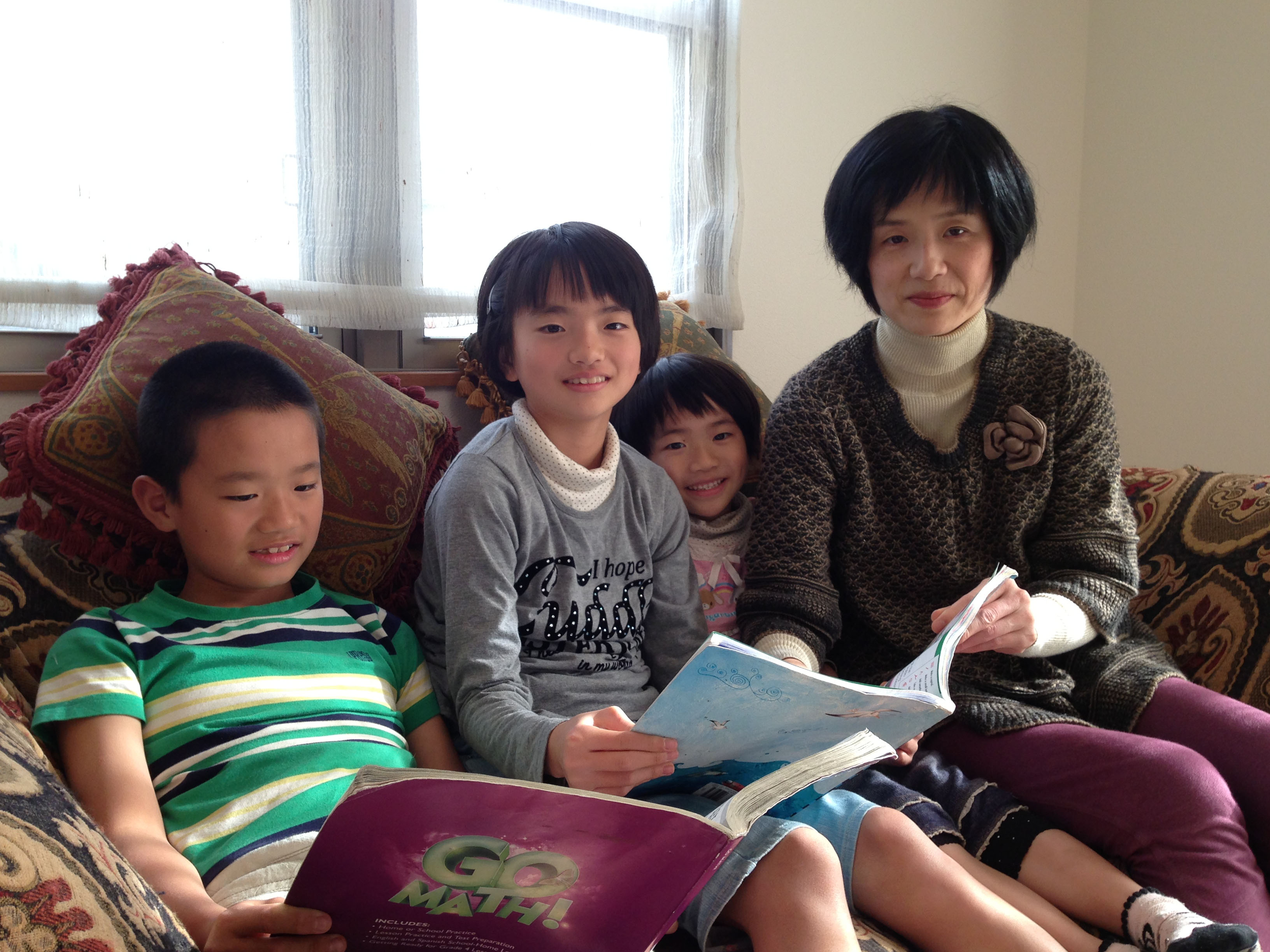 All in the family: Taichi (left), Mayu and Fuyu Sasada sit in their living room in December with their mother, Maho. | MAMI MARUKO