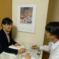 Home working: Midoriko Takahara discusses an English newspaper article with her son Reo. Takahara, who also runs a cram school in Tokyo, says she personally takes charge of her children\'s English education. | AKIHITO TAKAHARA