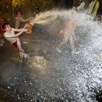 Brief return to childhood: Men wearing loincloths throw hot water at each other during the annual hot-spring water splashing festival held in Naganohara, Gunma Prefecture, on Monday. | KYODO