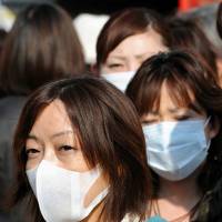 Pollen protection: Pedestrians wear face masks in Tokyo. | BLOOMBERG