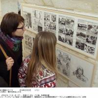 Disturbing images: Visitors look at some of the manga depicting wartime sexual slavery being exhibited at an international comic book festival in Angouleme, France. | KYODO