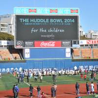 All together: Former or active tackle football players participated in the Huddle Bowl, a charity flag football tournament, on Sunday. | HIROSHI IKEZAWA