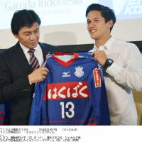 New horizons: Indonesian forward Irfan Bachdim (right) holds a Ventforet Kofu shirt on Monday after signing with the J. League first-division club. | KYODO