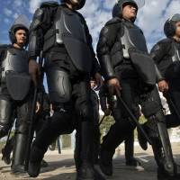 Move along: Egyptian riot policemen deploy to disperse supporters of Muslim Brotherhood ousted President Mohamed Morsi outside the police academy in Cairo on Wednesday, when the second hearing in his murder trial was to take place. Egypt: Morsi's trial adjourned until Feb. 1