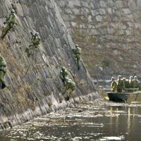 Self-Defense Forces personnel scrub the 20-meter-high stone walls surrounding Osaka Castle Park on Tuesday. The area is being spruced up for a series of events to celebrate the 400th anniversary of Osaka Fuyu no Jin (the Winter Siege of Osaka), a pivotal battle between the Tokugawa shogunate and the Toyotomi clan. | KYODO