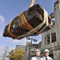 Granite rubble believed to be from the Hiroshima Peace Memorial, also known as the Atomic Bomb Dome, is lifted from the Motoyasu River on Wednesday. The chunk was apparently part of the third-floor eaves. Story: Page 2. | KYODO