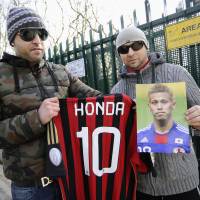 AC Milan fans hold up a picture of Keisuke Honda and a No. 10 shirt bearing his name after the Italian club officially introduced its new signing on Wednesday. Story: Page 12 | KYODO