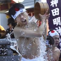 A young man douses himself with cold water during a purification ritual at Kanda Myojin Shrine in Chiyoda Ward, Tokyo, on Saturday.  AP | KYODO