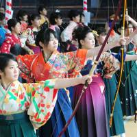 Young women take aim during a traditional archery contest in Sanjusangendo Hall in Higashiyama Ward, Kyoto, on Sunday, held to celebrate their coming of age. | KYODO