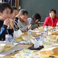 Pupils and a teacher at Nakagori Elementary School in Hamamatsu, Shizuoka Prefecture, eat lunch Tuesday. The lunch service in the city\'s public schools resumed after being halted Jan. 20 because nearly 1,000 pupils became sick during a massive outbreak of food poisoning likely caused by norovirus. | KYODO