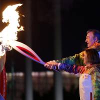 Russia\'s torchbearers Irina Rodnina (left) and Vladislav Tretyak light the Olympic cauldron Feb. 7 at the 2014 Winter Olympics opening ceremony. | AFP-JIJI
