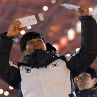 A member of the South Korean team cheers during the 2014 Winter Olympic opening ceremony. | AP