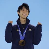Men\'s figure skating gold medalist Yuzuru Hanyu of Japan reacts during the awards ceremony at the 2014 Winter Olympics on Saturday. | AP