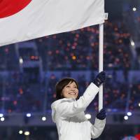 Ayumi Ogasawara of Japan holds the national flag during the closing ceremony of the 2014 Winter Olympics. | KYODO
